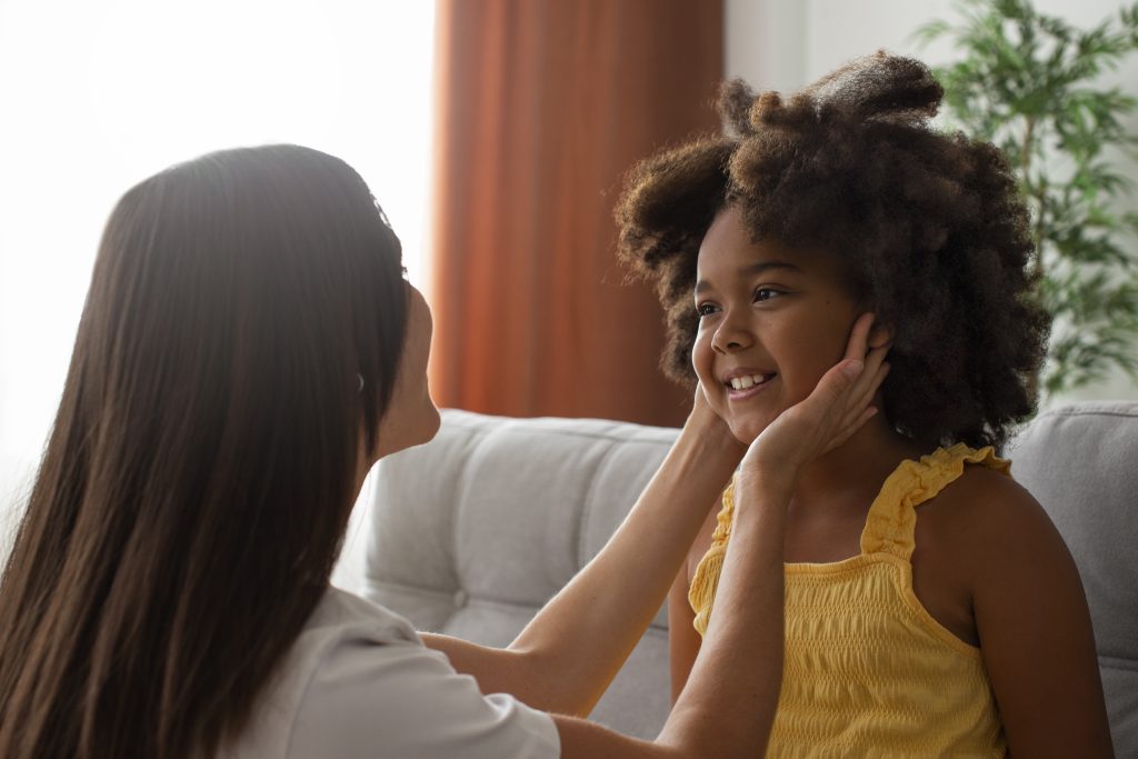 mom helping her child styling afro hair